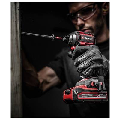 Eine Person mit Sicherheitsbrille und Handschuhen benutzt eine rote und schwarze elektrische Bohrmaschine auf einer Holzoberfläche und konzentriert sich auf ihre Aufgabe.