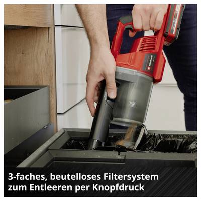 Person leert einen roten Akku-Staubsauger mit beutellosem Filtersystem per Knopfdruck in einen Mülleimer; Text: '3-faches, beutelloses Filtersystem zum Entleeren per Knopfdruck'