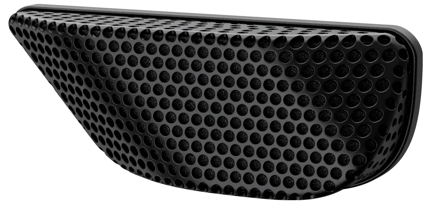 Eine gekrümmte, schwarze, gelochte Lautsprecherabdeckung, die aus einem Winkel betrachtet wird und ihr bienenwabenähnliches Muster zeigt.