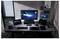Ein moderner Arbeitsbereich mit einem großen Monitor, der eine Science-Fiction-Landschaft zeigt, zwei Laptops links und rechts, einem Grafiktablett und einer Tastatur.