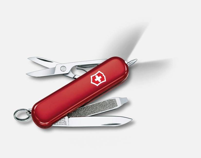 Rotes Schweizer Taschenmesser mit mehreren geöffneten Werkzeugen, darunter Schere, Nagelfeile und Messerklinge, auf weißem Hintergrund.