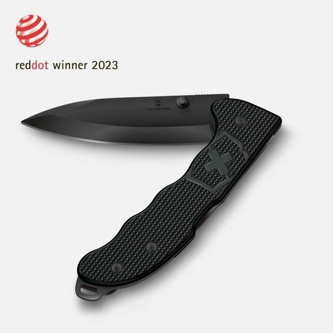 Schwarzes Victorinox-Klappmesser mit strukturiertem Griff, offen neben dem Logo des Preises „Red Dot Winner 2023" dargestellt.