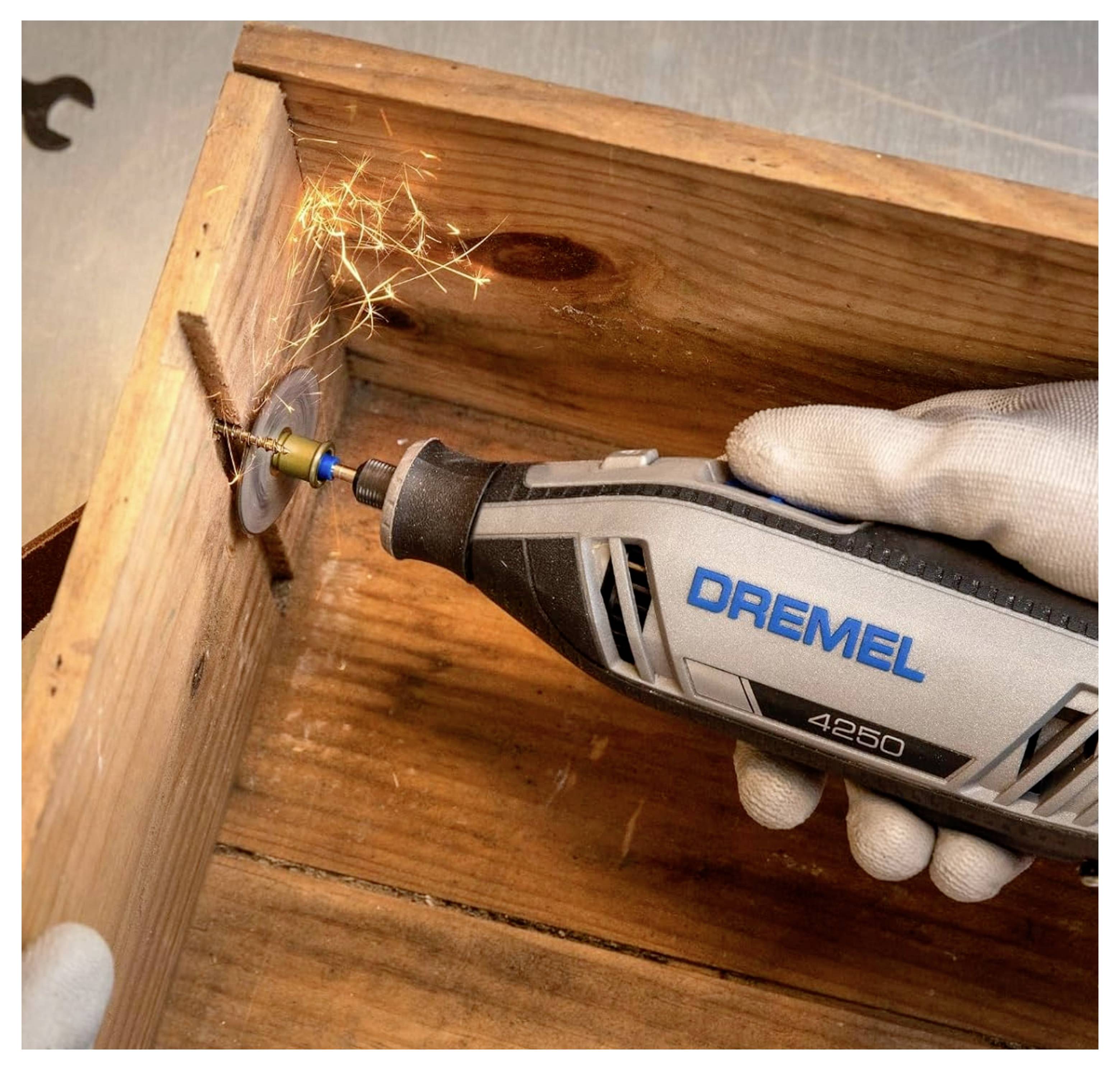 Eine Person verwendet ein Dremel 4250-Werkzeug mit einer Trennscheibe, um eine Holzkiste zu zerschneiden, wobei Funken entstehen. Das Werkzeug wird mit einer behandschuhten Hand gehalten.