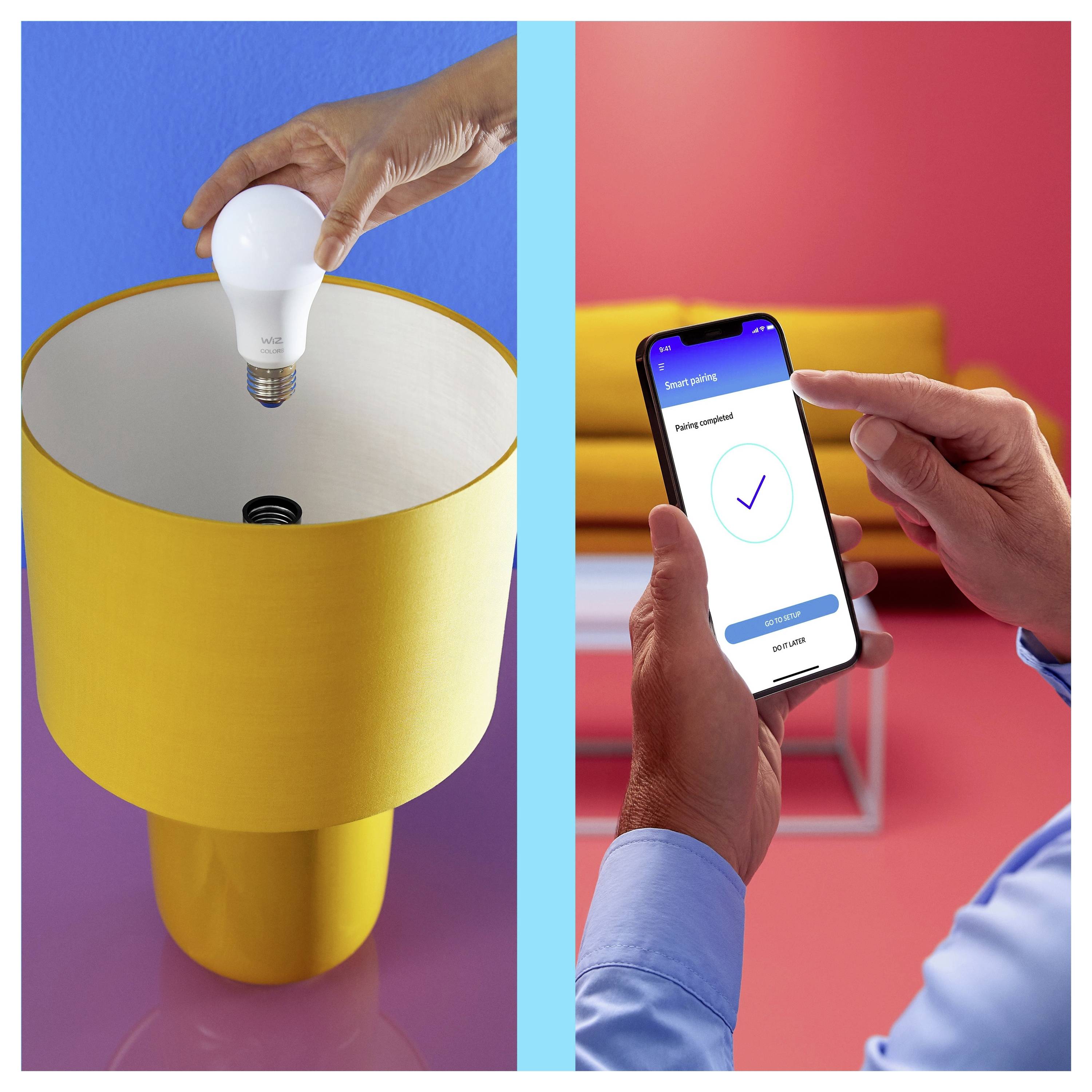 Eine Person installiert eine Smart-Glühbirne in einer gelben Lampe, während eine andere eine Smartphone-App prüft, auf der "Setup abgeschlossen" angezeigt wird.