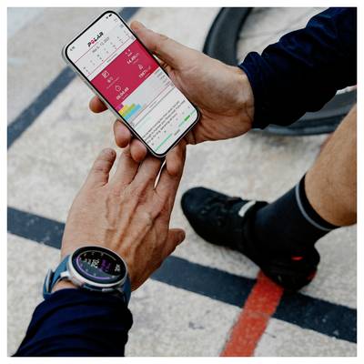 Eine Person überprüft Fitnessdaten auf einem Smartphone mithilfe einer Gesundheits-App. Eine andere Person streckt die Hand aus, um den Bildschirm zu teilen oder darauf zu zeigen.