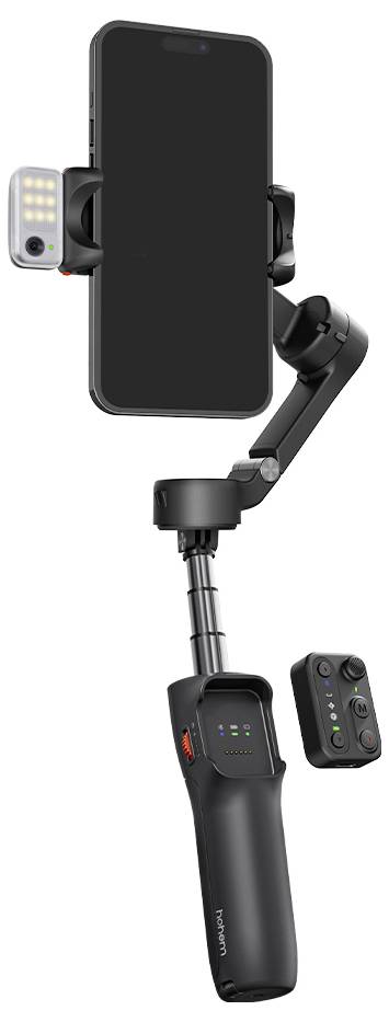 Ein Smartphone, das auf einem schwarzen, handgehaltenen Gimbel-Stabilisator montiert ist, mit einer kleinen LED-Leuchte, die angebracht ist. Eine Fernbedienung liegt in der Nähe.