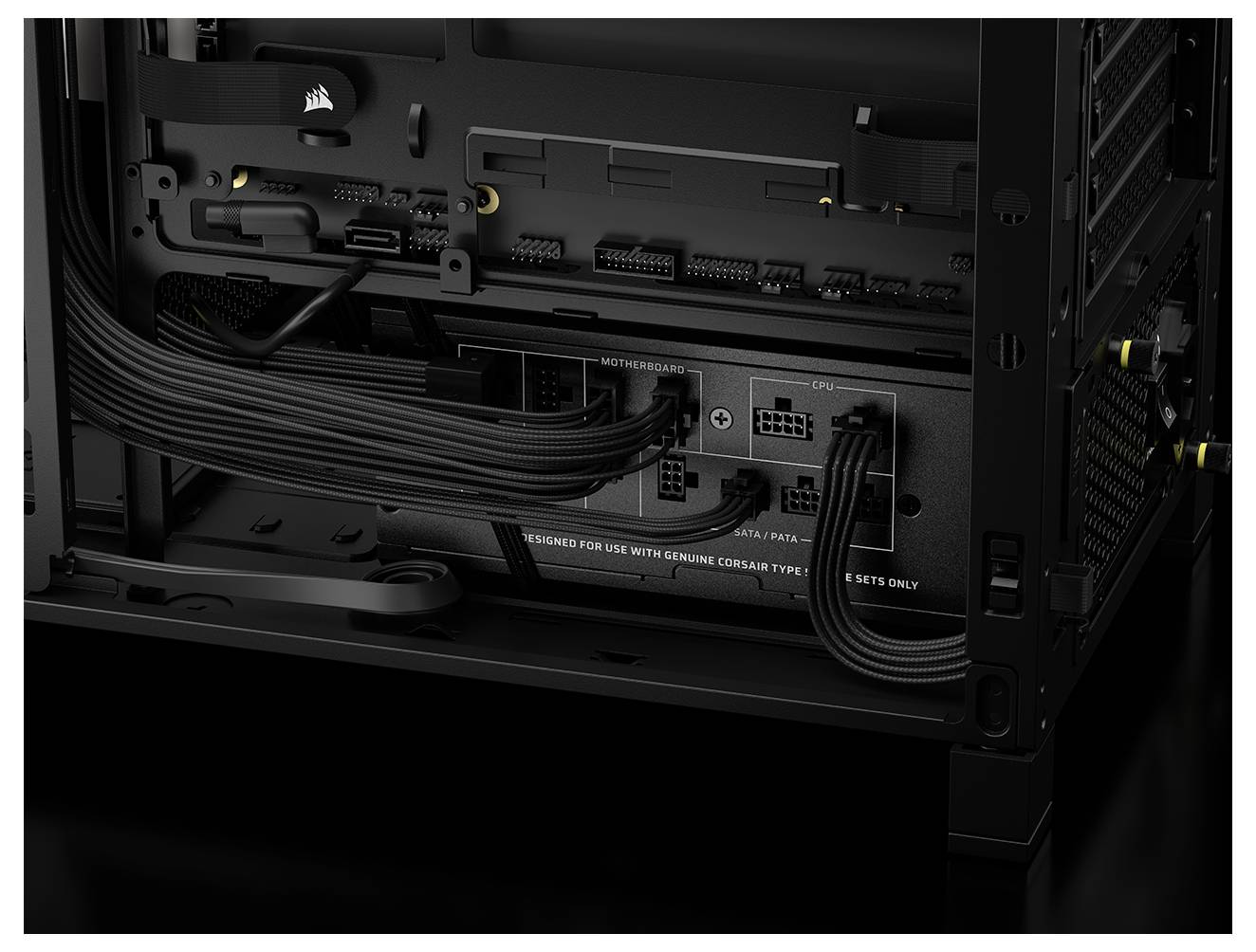 Ein Computergehäuse, das das Kabelmanagement im Inneren zeigt, mit schwarzen Kabeln, die ordentlich an ein Netzteil angeschlossen sind, mit beschrifteten Anschlüssen für GPU und Mainboard.