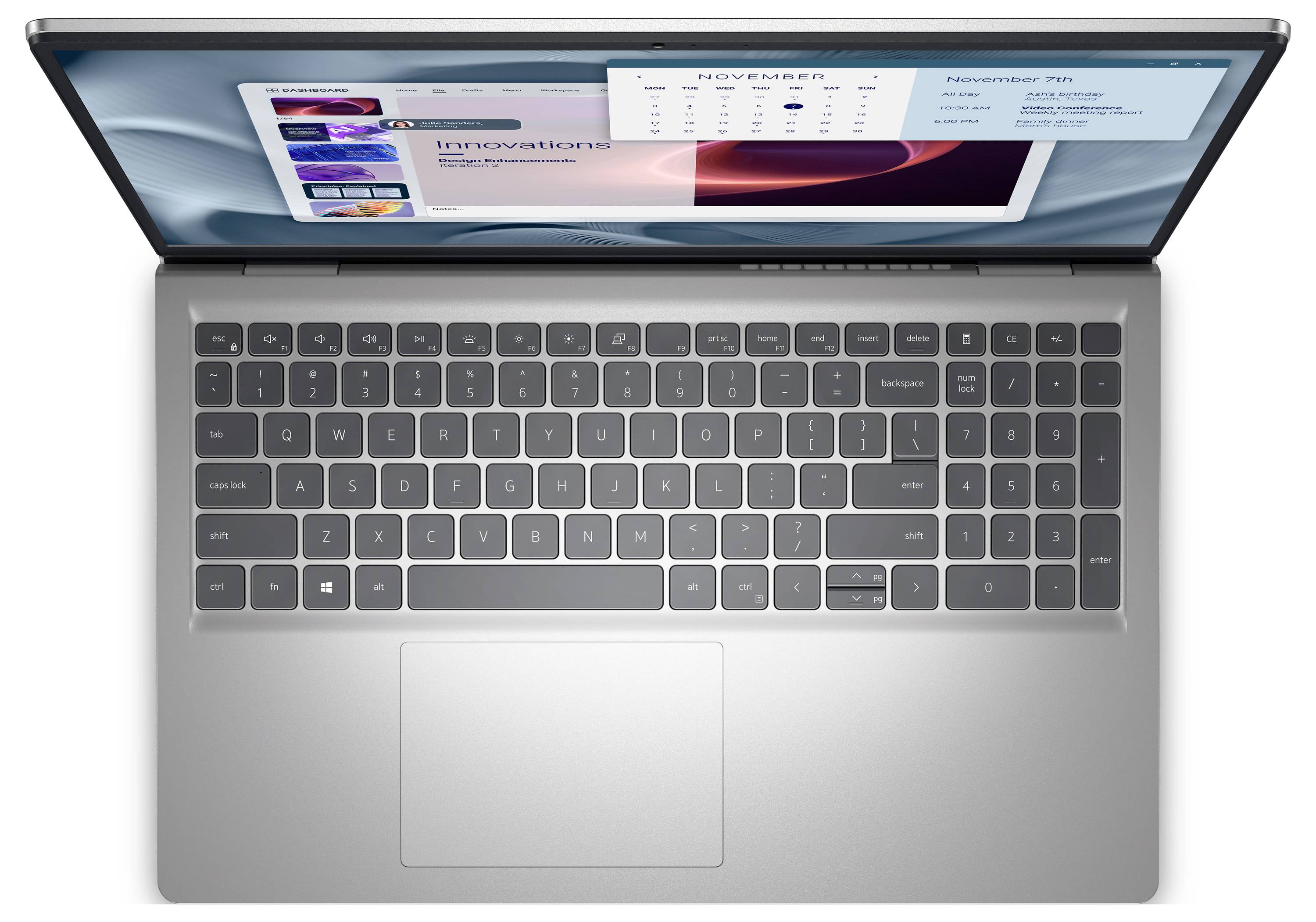 Ein Laptop mit sichtbarer Tastatur und Touchpad, der einen Bildschirm mit einem Kalender für November und einem Bildkarussell von technologischen Innovationen zeigt.