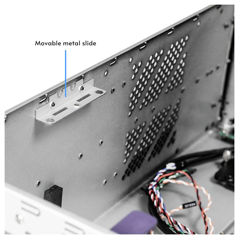 Inneres eines Computergehäuses mit einem beschrifteten 'beweglichen Metallschieber' auf dem gelochten Metallseitenpaneel, neben Verkabelung.