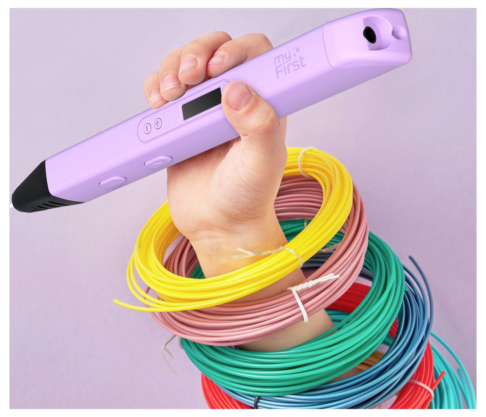 Eine Hand hält einen lila 3D-Stift mit der Aufschrift "myFirst", mit bunten Filamentspulen um das Handgelenk gewickelt, vor einem hellen Hintergrund.