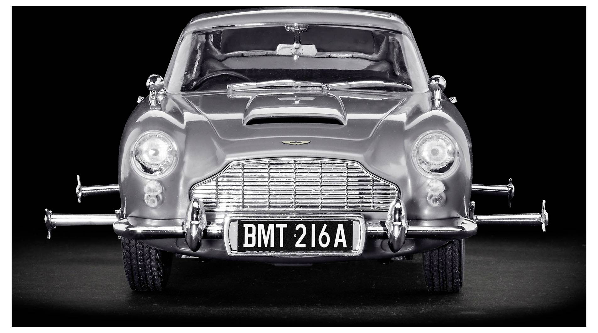 Frontansicht eines klassischen silbernen Sportwagens mit einem Chromgrill, zwei großen Scheinwerfern und einem Nummernschild mit der Aufschrift "BMT 216A".