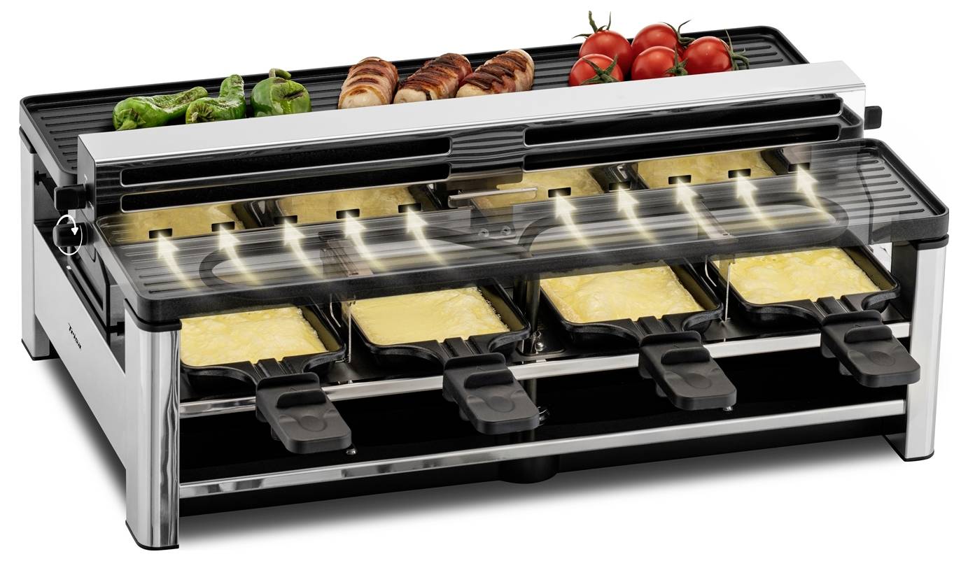 Ein Raclette-Grill mit mehreren Pfännchen, gefüllt mit geschmolzenem Käse. Darauf liegen Würstchen, Paprika und Tomaten.