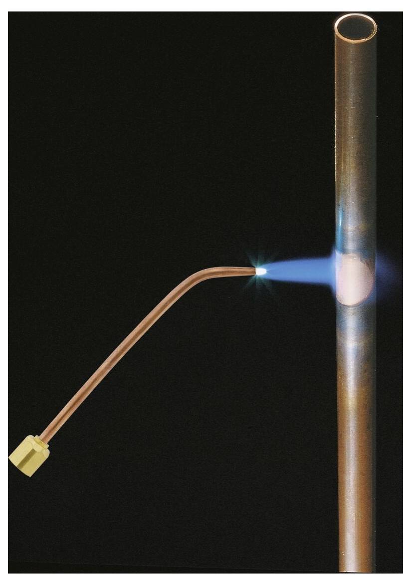 Eine Kupferrohrleitung, die mit einem Schweißbrenner geschweißt wird und eine blaue Flamme ausstößt.