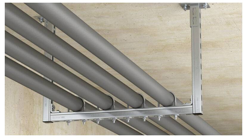Rohre verlaufen parallel entlang einer Decke und werden durch eine metallische Halterung gestützt. Die Anordnung deutet auf eine industrielle oder Baustelle hin.