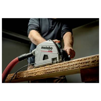 Person, die eine Metabo-Kreissäge zum Schneiden eines Holzbretts verwendet, mit angeschlossenem Staubschlauch.