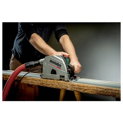 Person, die eine Metabo-Kreissäge mit einem Staubsaugerschlauch verwendet, um ein Holzbrett auf einer Werkbank zu sägen.
