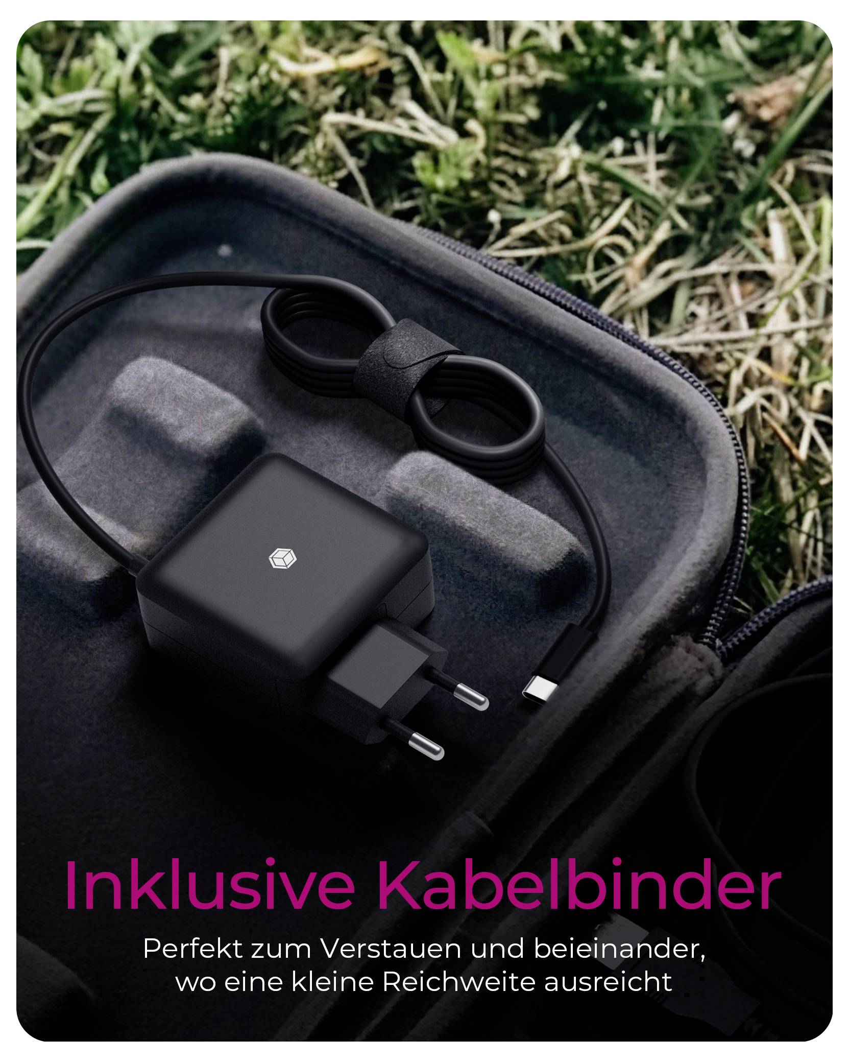 Ein schwarzes Ladegerät mit einer Kabelbinder auf Gras und einer Reißverschlusstasche liegend.