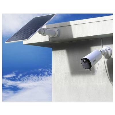 Eine Sicherheitskamera, die an der Ecke eines Gebäudes montiert ist und von einem Solarpanel unter einem blauen Himmel mit Strom versorgt wird, veranschaulicht eine solargestützte Überwachung.