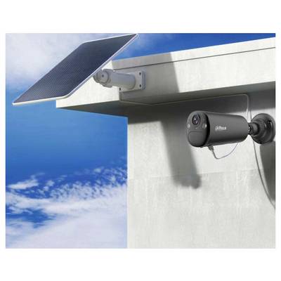 Eine Sicherheitskamera und ein Solarpanel, die an einer Gebäudeecke unter einem klaren blauen Himmel montiert sind und damit eine solarbetriebene Überwachungseinrichtung präsentieren.