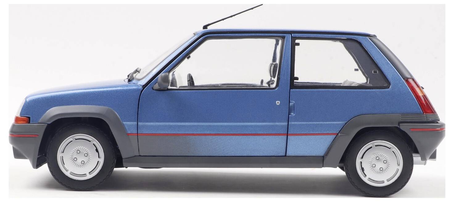 Ein blauer kompakter Schrägheck-Wagen wird in einer Seitenansicht vor einem einfarbigen Hintergrund gezeigt. Das Fahrzeug hat einen roten Streifen entlang der Seite.