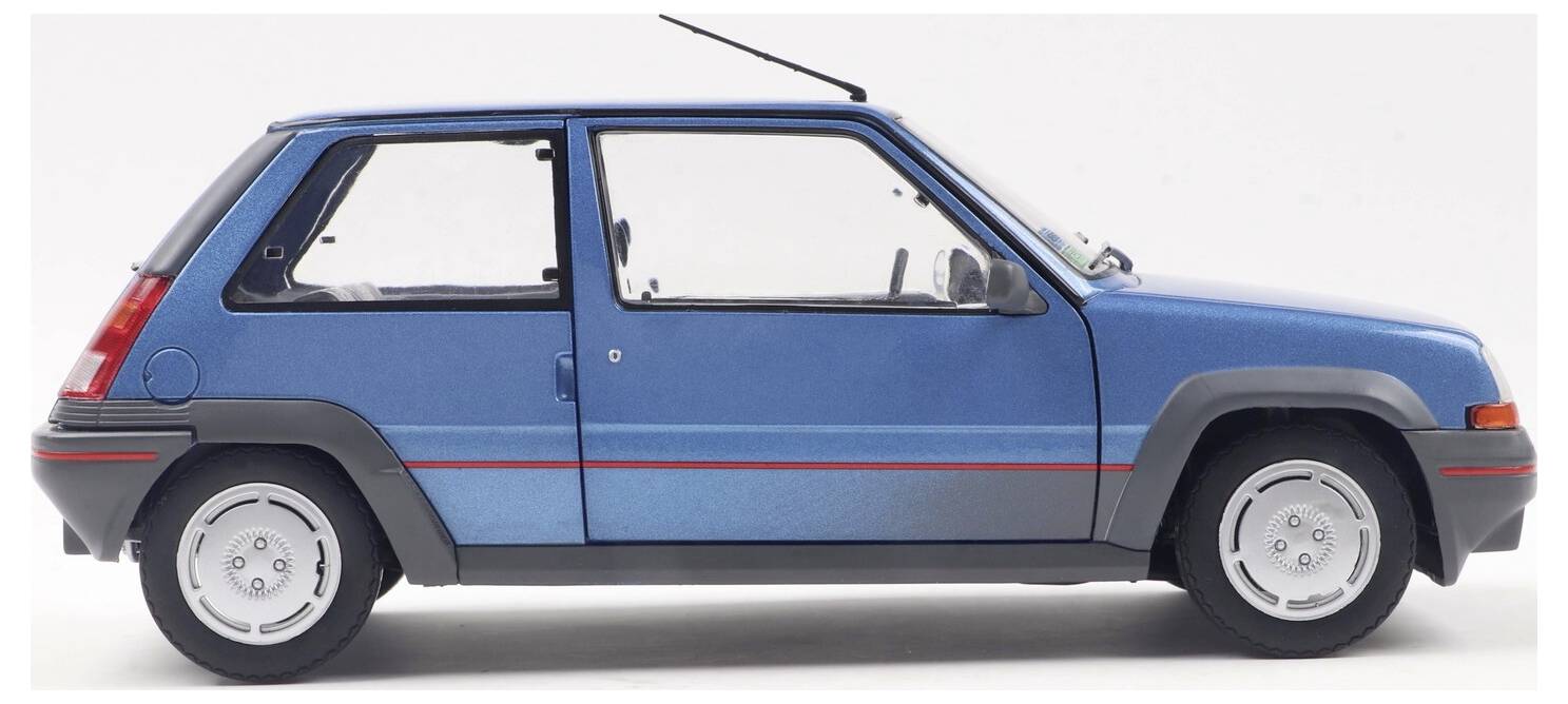 Ein blauer Kompaktwagen, Seitenansicht, mit einem roten Streifen entlang der Karosserie. Das Auto ist geparkt und im Profil vor einem schlichten Hintergrund dargestellt.