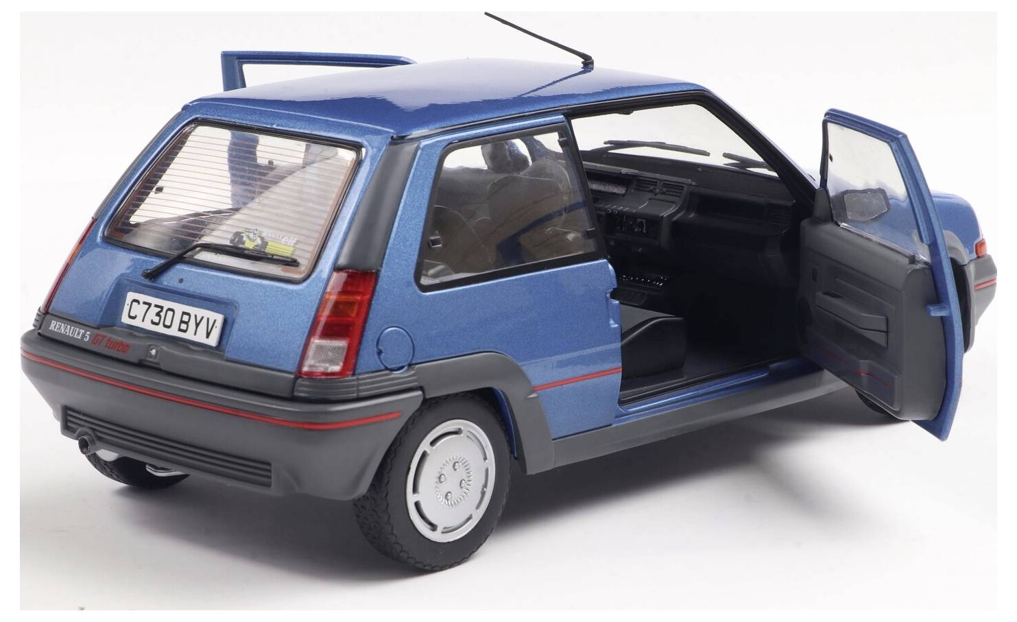 Ein blauer Retro-Schrägheckwagen mit geöffneten Türen, der das Interieur zeigt. Das Auto ist in einem Winkel positioniert, wodurch sein kompaktes Design betont wird.