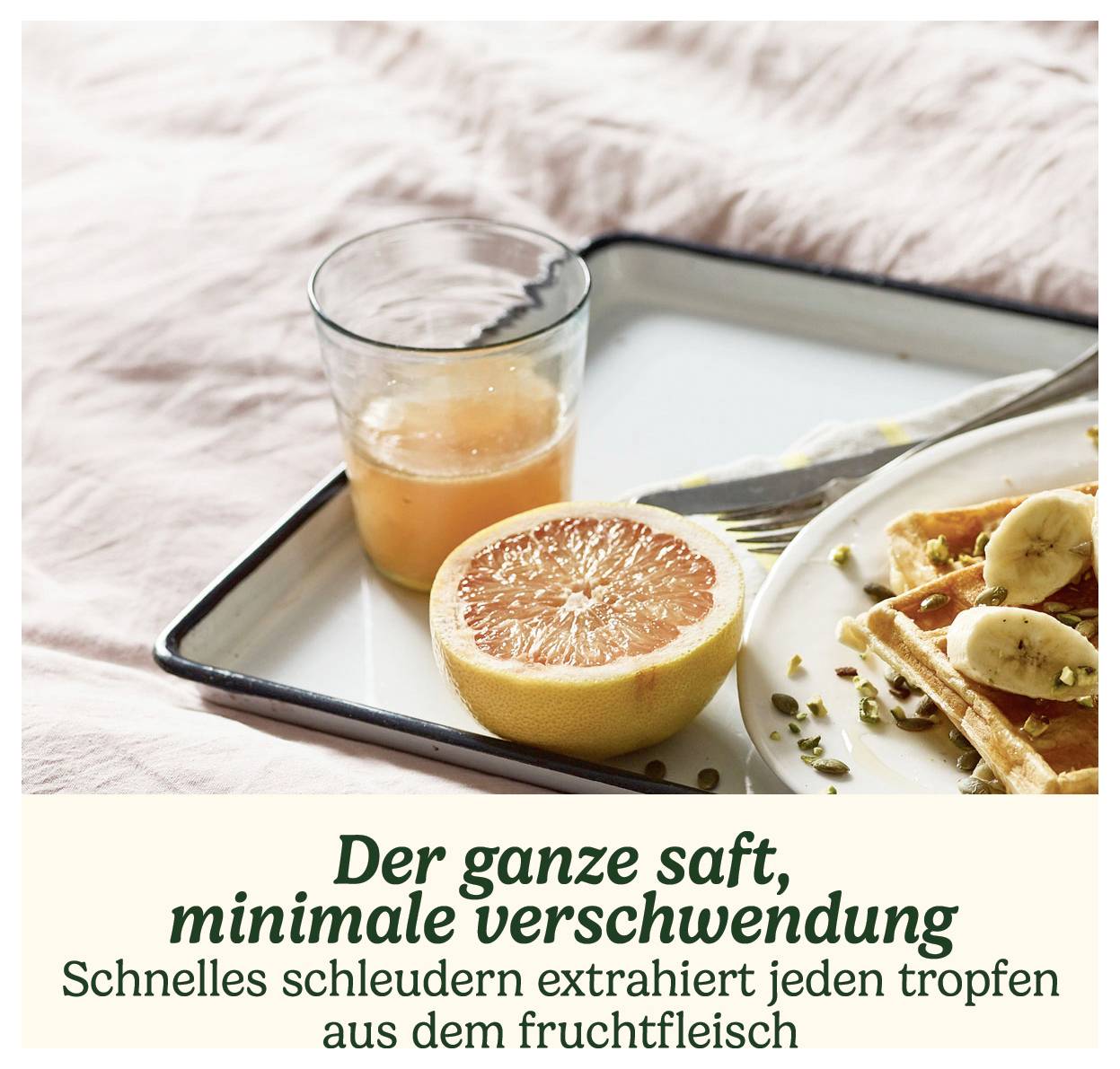 Ein Tablett mit einem Glas Grapefruitsaft, einer halben Grapefruit und einem Waffelteller mit Bananenscheiben und Nüssen. Text: 'Der ganze saft, minimale verschwendung'.