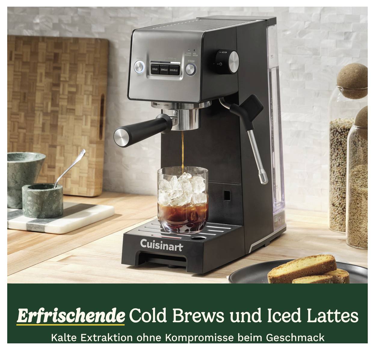 Espressomaschine auf Küchenarbeitsplatte, brüht Kaffee in Glas mit Eis. Text darunter: 'Erfrischende Cold Brews und Iced Lattes'.