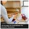 Person sitzt auf dem Boden und arbeitet mit Werkzeug an einem Holzschrank. Elektronisches Gerät und LED-Anzeige zeigen Heizstatus.