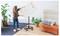 Eine Person richtet eine rotierende Whiteboardtafel mit der Aufschrift "Projektplanung" in der Nähe eines modernen Sofas und Pflanzen in einem zeitgemäßen Büro ein.