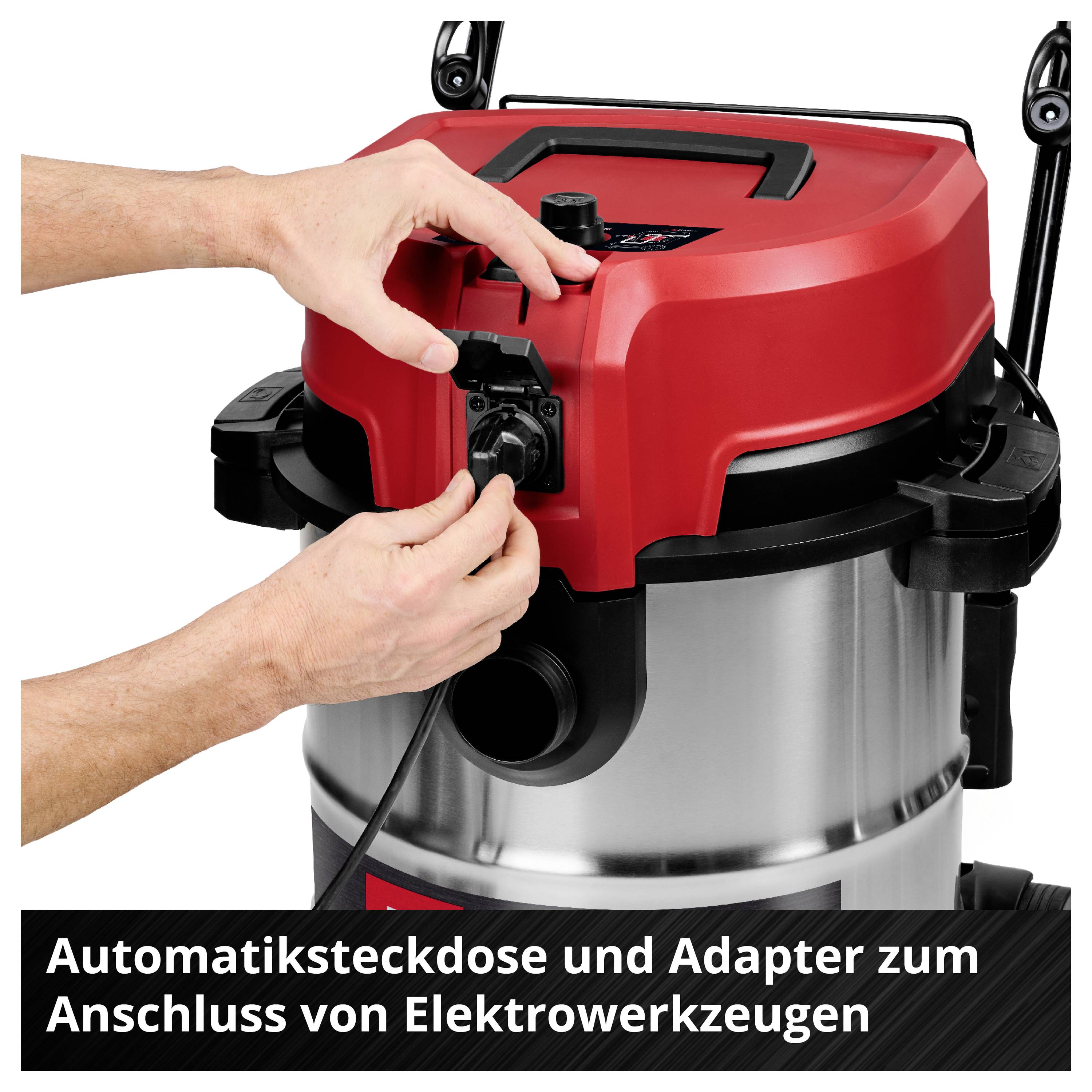 Eine Person schließt ein Elektrowerkzeug an die Automatiksteckdose eines roten, metallischen Staubsaugers an.