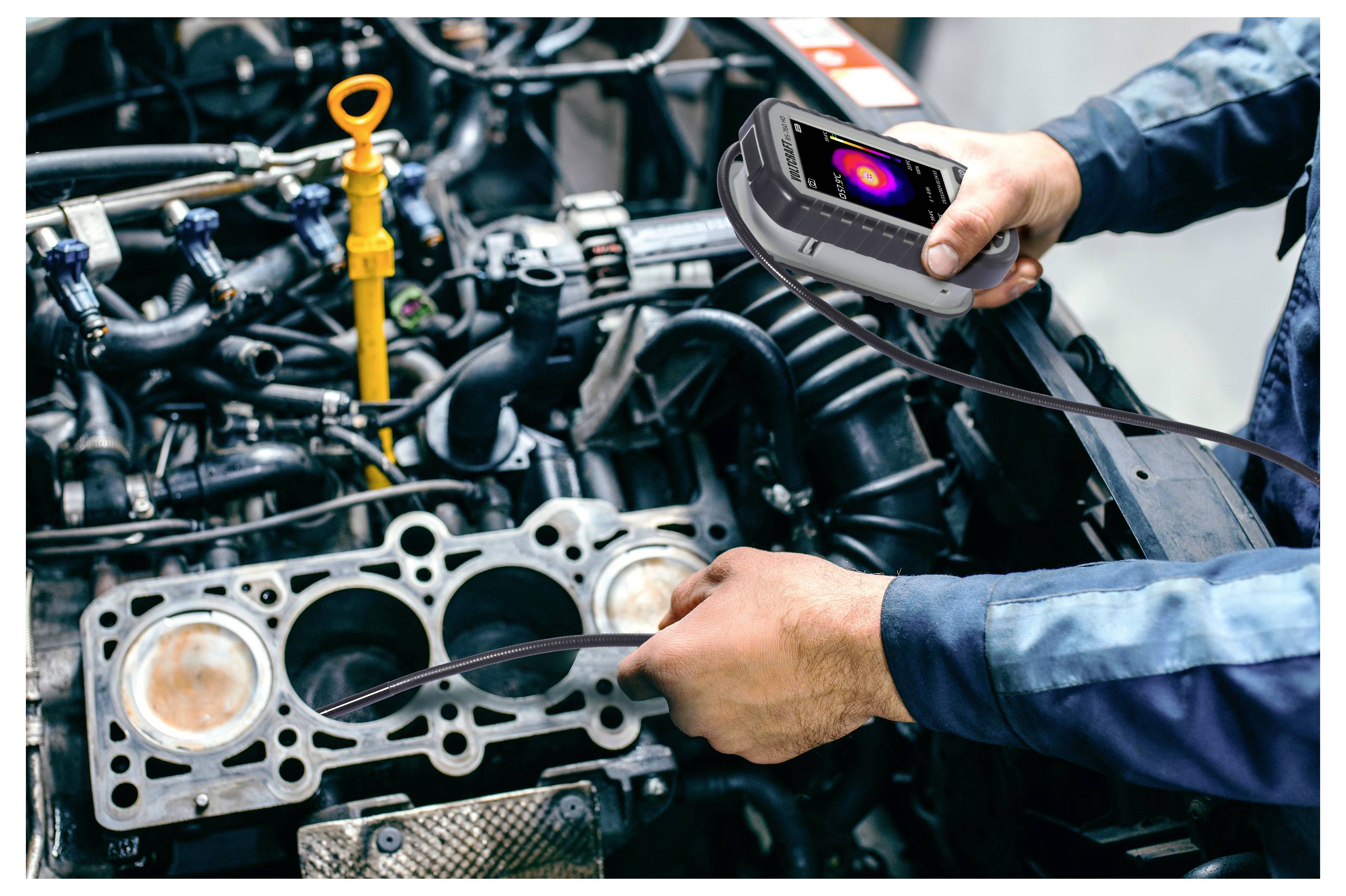 Ein Mechaniker nutzt eine Wärmekamera, um einen Motorblock während einer Reparatur zu inspizieren und auf Wärmprobleme oder Lecks zu prüfen.
