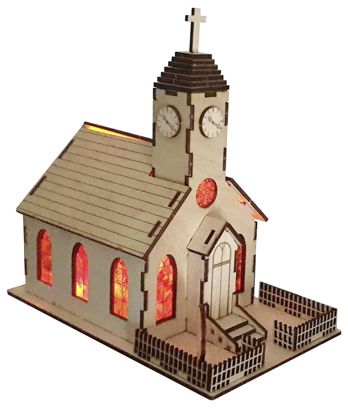 Eine kleine Holzkirche im Modell mit beleuchteten Buntglastfenstern und einem Glockenturm, umgeben von einem weißen Lattenzaun.