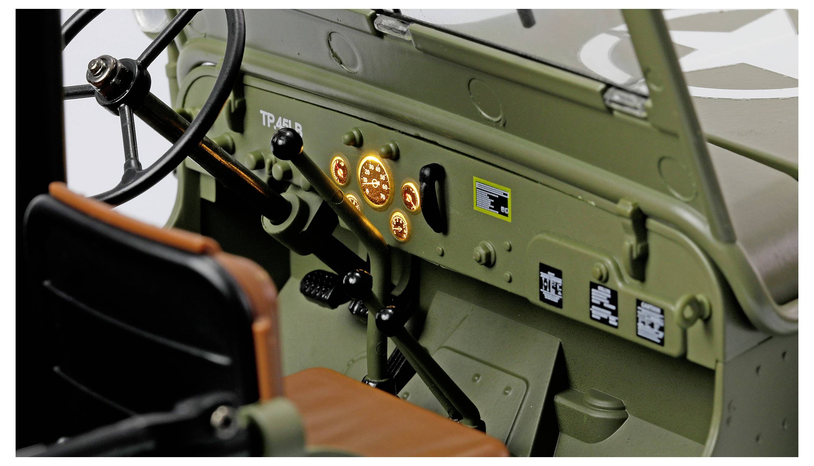 Interieur eines Militärjeeps mit Blick auf das Lenkrad, beleuchtete Armaturenbrettkontrollen und Schalthebel mit olivgrünen Akzenten.
