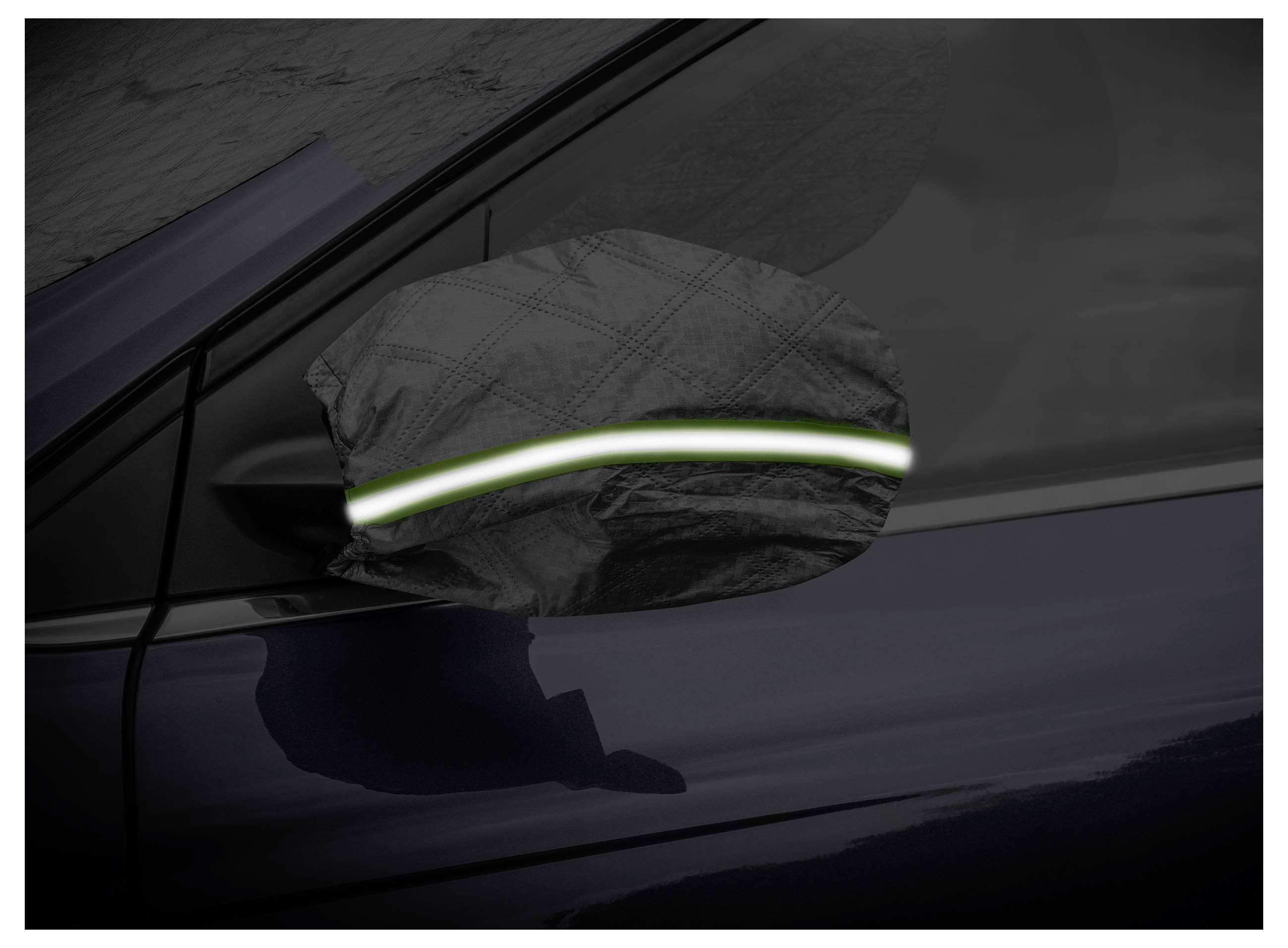 Ein Außenspiegel eines Autos ist unter schlechten Lichtverhältnissen mit einem schwarzen und reflektierenden Material bedeckt, wobei die Sichtbarkeit durch eine leuchtende Linie verbessert wird.