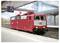 Eine rote Lokomotive mit den Beschriftungen „DB" und „SE1" steht auf einem leeren Bahnsteig unter einem Überkopfschild, das die Nummer „5" zeigt.