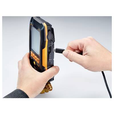 Eine Person steckt ein USB-Kabel in ein handgehaltenes Diagnosegerät mit orange-schwarzem Design, was auf Ladung oder Datenübertragung des Geräts hindeutet.