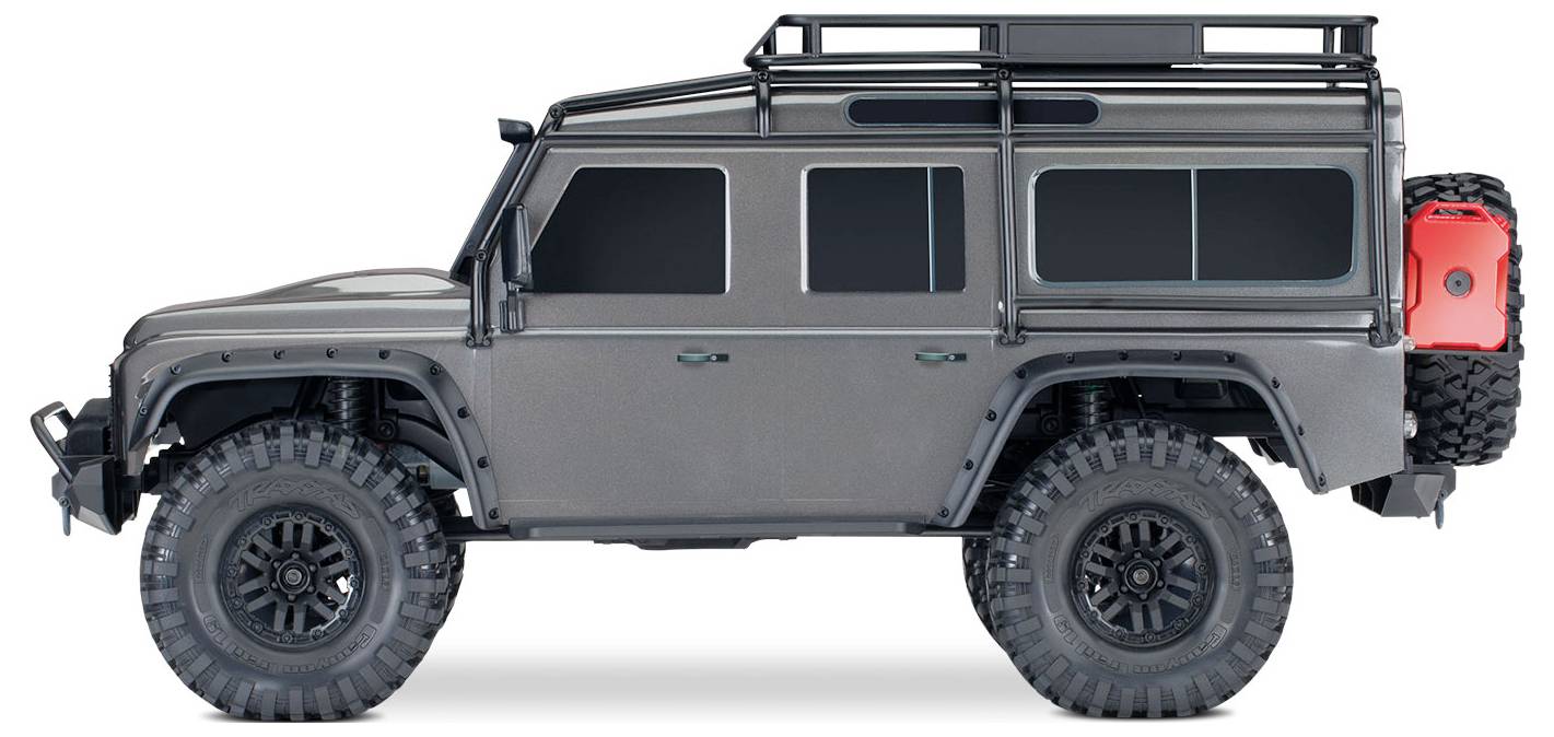 Grauer SUV-Modell mit Dachträger und seitlich angebrachtem roten Kanister, großen Geländereifen und getönten Scheiben, von der Seite betrachtet.
