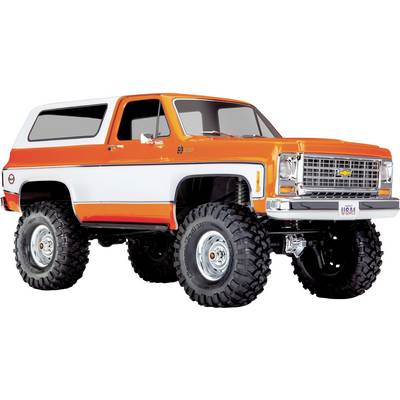Ein heller orange-weißer Vintage-SUV mit großen Geländereifen, von einem Winkel aus betrachtet. Das Fahrzeug hat einen Retro-Stil und eine robuste Bauweise.