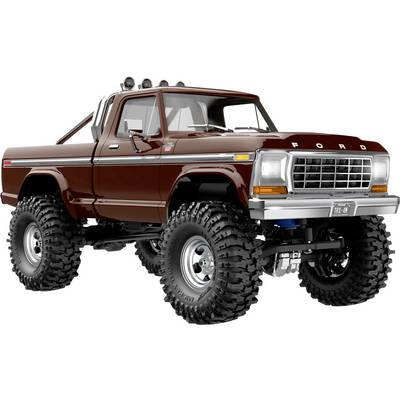 Ein maßgeschneiderter Vintage-Pickup-Truck mit großen Geländereifen, angehobener Federung und dunkler Rotlackierung. Er präsentiert ein klassisches Design.