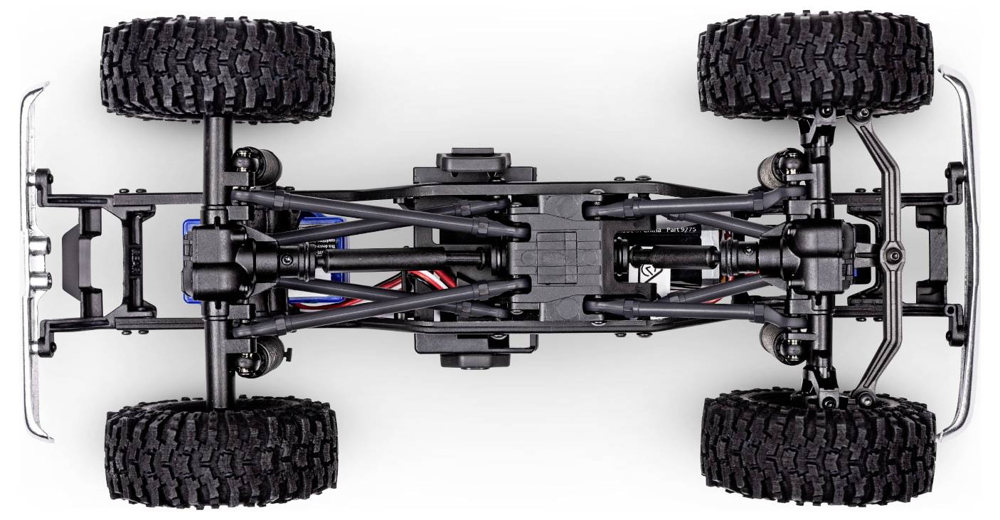 Draufsicht eines detaillierten Modell-Autochassis, das große strukturierte Reifen, Metallachsen und sichtbare Federbeinkomponenten hervorhebt.