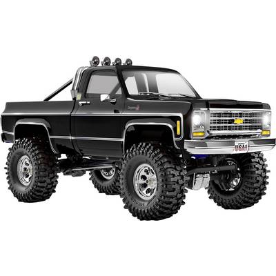 Ein gehobener schwarzer Chevrolet-Truck mit überdimensionalen Reifen und Chromdetails betont seine robusten Offroad-Fähigkeiten.