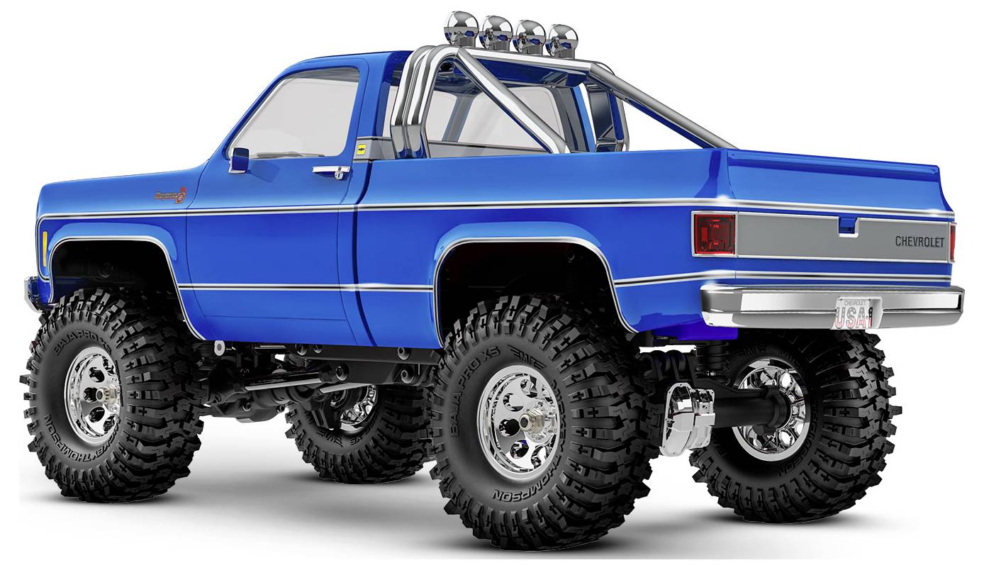 Blauer Chevrolet-Monstertruck mit großen Geländereifen und Chrom-Akzenten, auf weißem Hintergrund geparkt, der sein robustes Design präsentiert.
