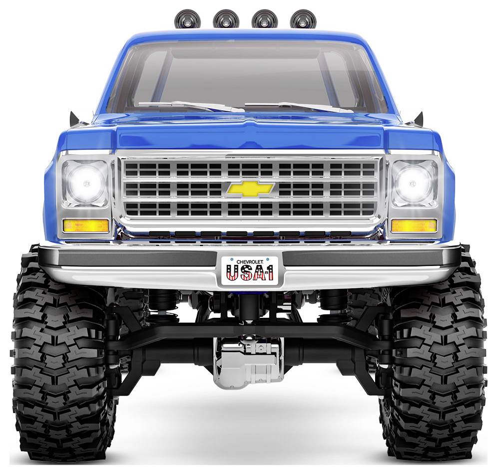 Ein blauer Chevrolet-Truck mit großen Geländereifen und einem Nummernschild mit der Aufschrift 'USA1', von vorne betrachtet, der sein robustes Design zur Geltung bringt.