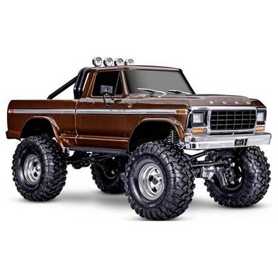 Ein brauner Pickup-Truck mit großen Geländereifen, Chromdetails und Dachbeleuchtung. Der Truck ist ein Klassiker mit Retro-Design.