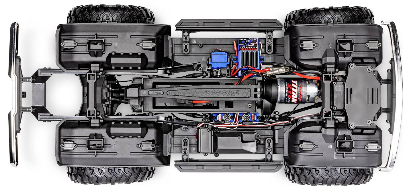 Draufsicht eines Fernsteuerwagen-Fahrgestells mit vier großen Reifen, zentralem Motor, elektronischen Komponenten und Federungssystem.