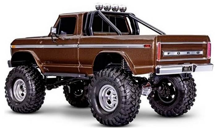 Ein brauner Ford-Pickup-Truck mit überdimensionalen Geländereifen und Überrollbügeln, von der hinteren linken Seite aufgenommen, der ein robustes Design präsentiert.