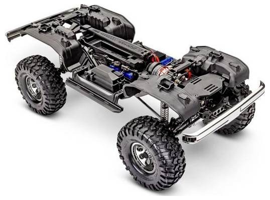 Eine detaillierte Ansicht eines Geländewagen-Fernsteuerungsautochassis mit sichtbarer Federung, großen Reifen und Motorkomponenten.