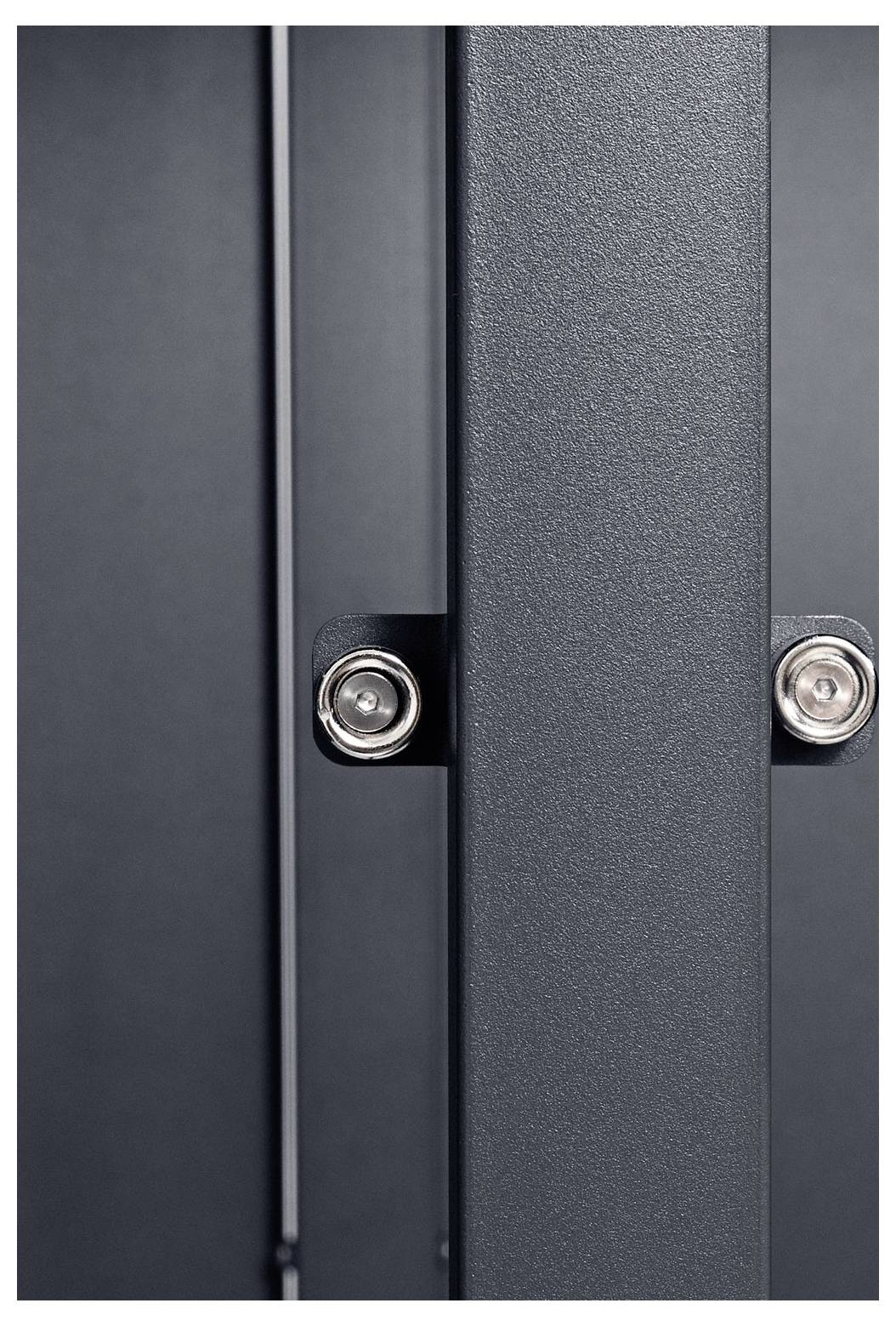 Eine Nahaufnahme einer modernen, dunkelgrauen Metallstruktur mit sichtbaren Schrauben, die eine robuste Konstruktion und industrielle Designelemente präsentiert.