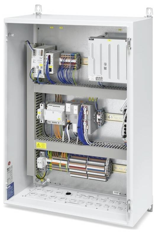 Ein offenes elektrisches Schaltfeld, das verschiedene Drähte, Schalter und Schaltungskomponenten zeigt, die auf drei Regalen in einer Metallbox organisiert sind.